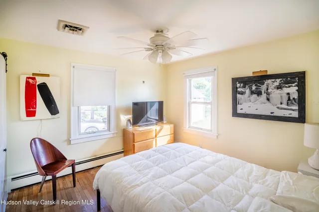 a bedroom with a bed and a chair with the potted plant