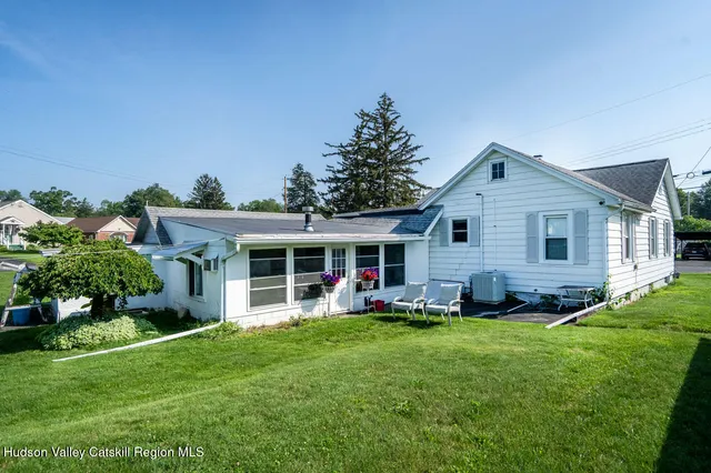 a front view of a house with a yard and trees