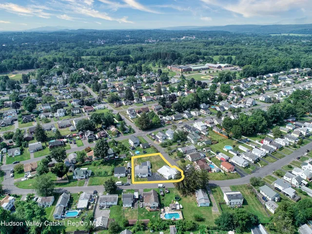 an aerial view of residential houses with outdoor space and trees