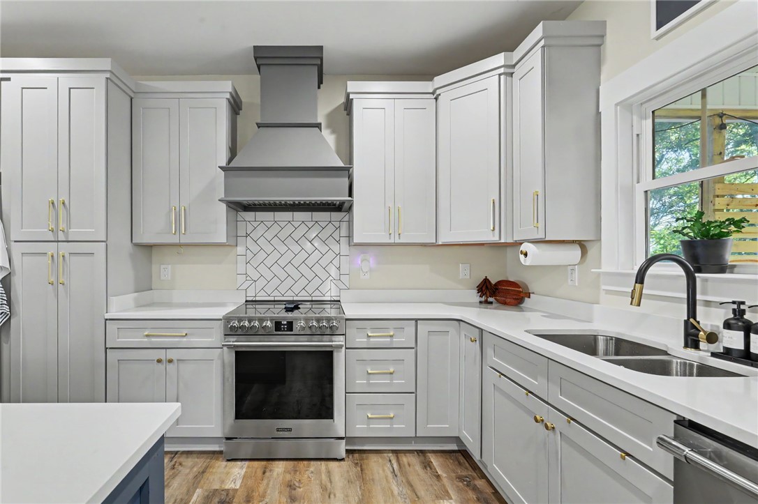 Shaker-style cabinetry, quartz countertops and stainless steel appliances highlight the kitchen, with the screened porch just steps away.