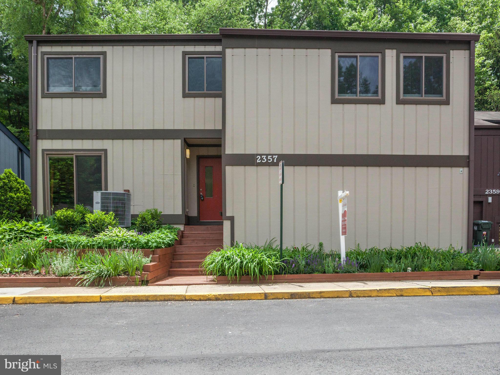 2357 Glade Bank Way Reston, VA 20191 - Photo 1 of 30 a front view of a house with a yard and garage