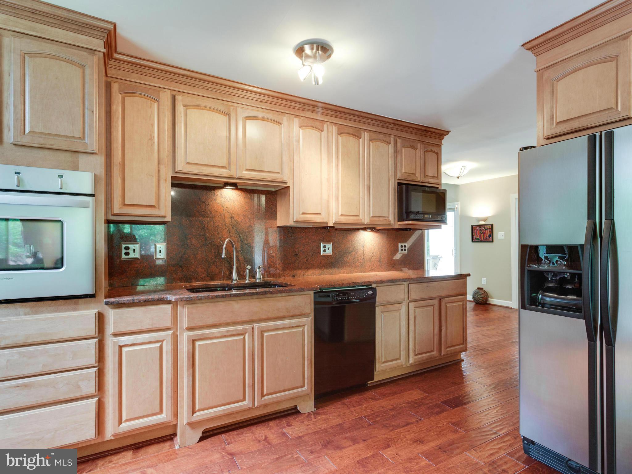 2357 Glade Bank Way Reston, VA 20191 - Photo 6 of 30 a kitchen with granite countertop white cabinets and stainless steel appliances