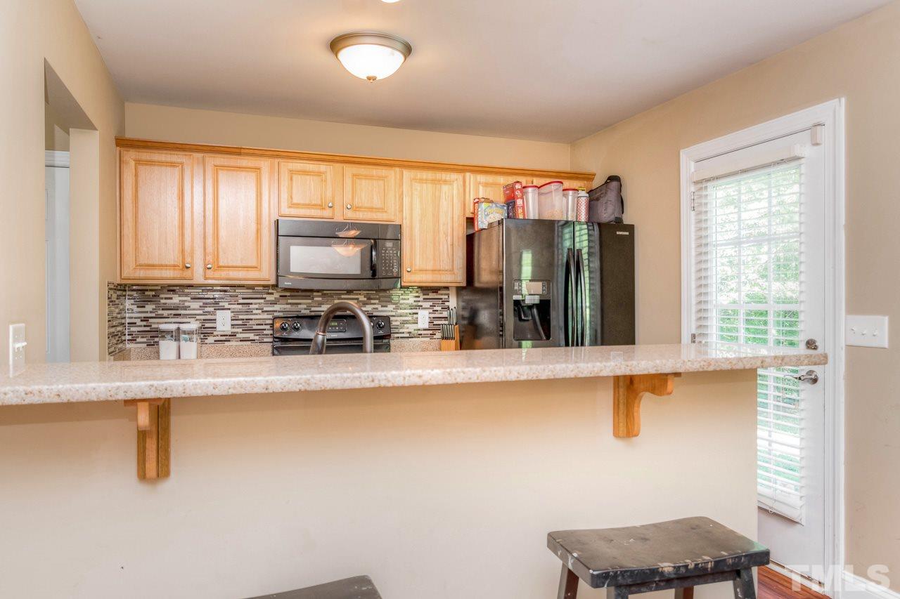210 Orkney Road Stem, NC 27581 - Photo 13 of 26 a kitchen with stainless steel appliances granite countertop a stove a sink and a microwave