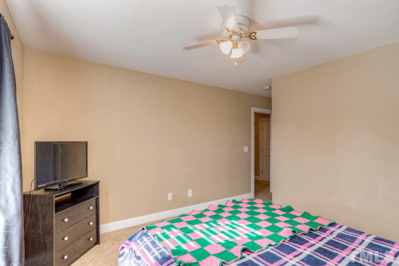 210 Orkney Road Stem, NC 27581 - Photo 17 of 26 a bedroom with a bed and a flat screen tv