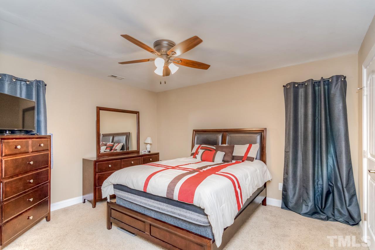 210 Orkney Road Stem, NC 27581 - Photo 21 of 26 a bedroom with a bed and a flat screen tv