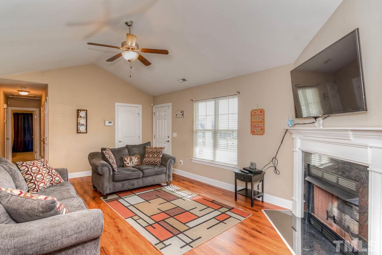 210 Orkney Road Stem, NC 27581 - Photo 9 of 26 a living room with furniture a flat screen tv and a fireplace