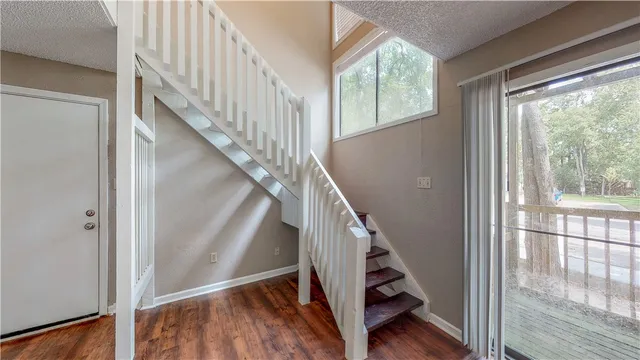 a view of staircase with wooden floor and white walls