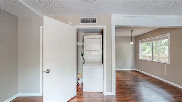 a view of a hallway with wooden floor and a bathroom