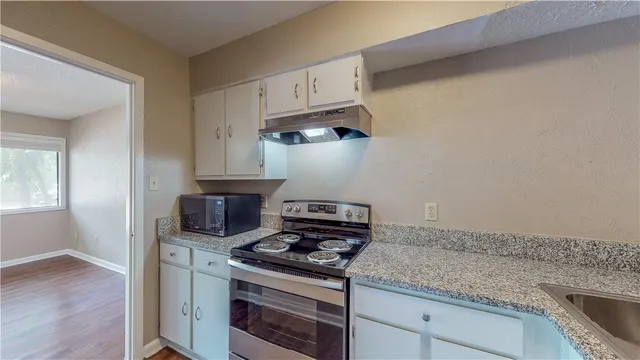 a kitchen with white cabinets and appliances