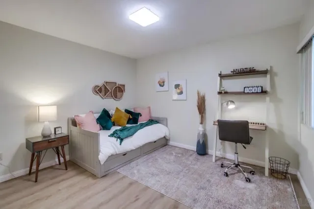 a bedroom with a bed and painting on the wall