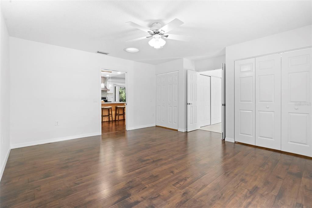 2053 Bond Road DeLand, FL 32720 - Photo 13 of 51 an empty room with wooden floor chandelier fan and windows