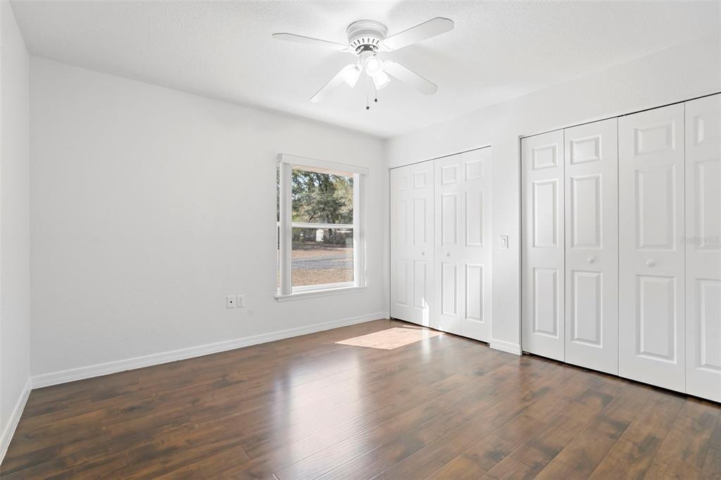 2053 Bond Road DeLand, FL 32720 - Photo 23 of 51 an empty room with wooden floor chandelier fan and windows