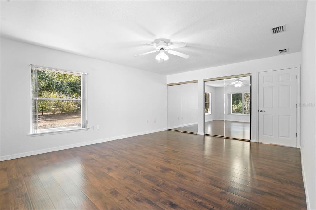 2053 Bond Road DeLand, FL 32720 - Photo 27 of 51 an empty room with wooden floor chandelier fan and windows