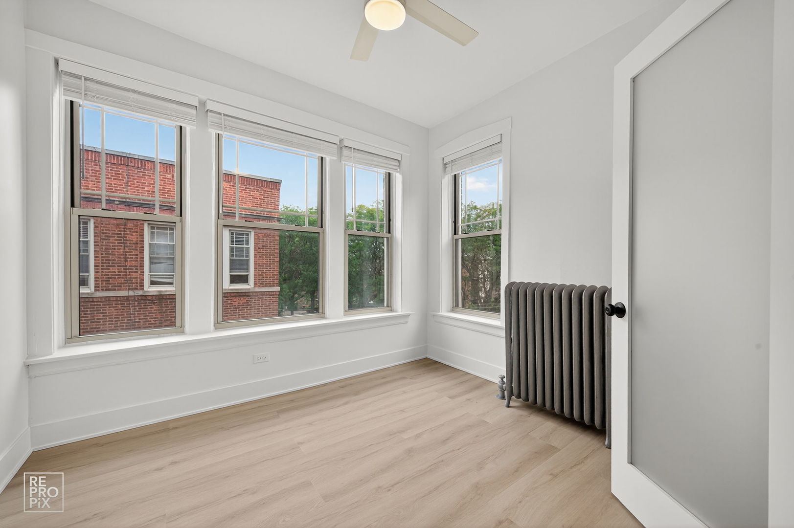 6977 North Bell Avenue, Unit 3 Chicago, IL 60645 - Photo 7 of 15 an empty room with wooden floor and windows