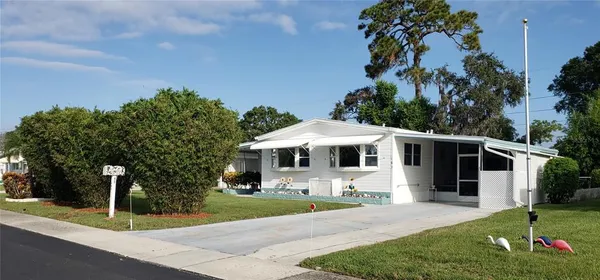 a front view of a house with a yard and trees