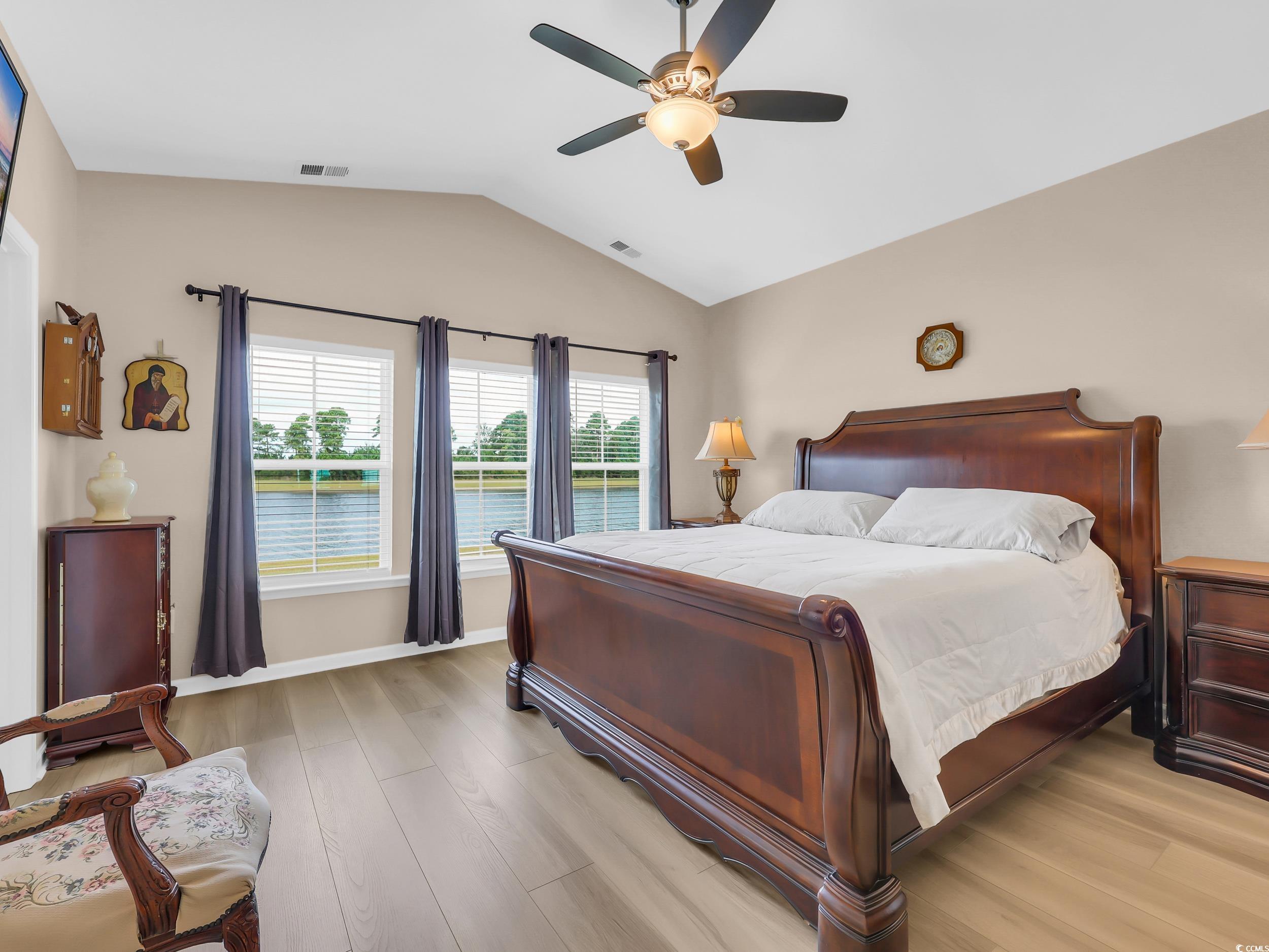 322 Augusta Grn Way Myrtle Beach, SC 29579 - Photo 19 of 34 Bedroom featuring light wood-type flooring, lofted ceiling, ceiling fan, and a water view