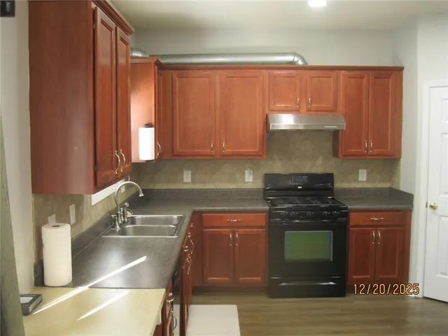 a kitchen with stainless steel appliances wooden cabinets and a stove top oven