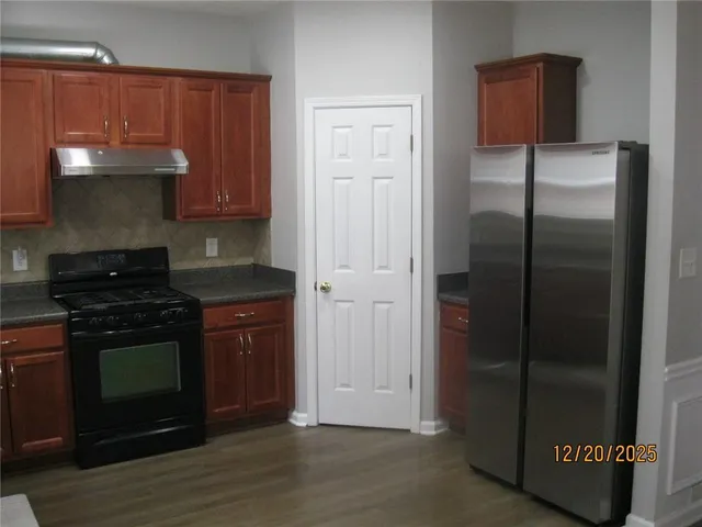 a kitchen with stainless steel appliances granite countertop a refrigerator and a stove