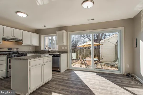 a kitchen with a table chairs and a wooden floor