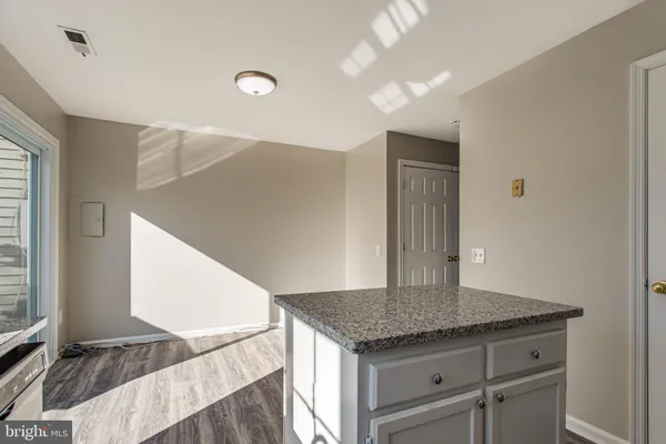 a kitchen with a granite countertop sink and cabinets