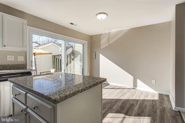 a kitchen with kitchen island a large window a sink and living room view