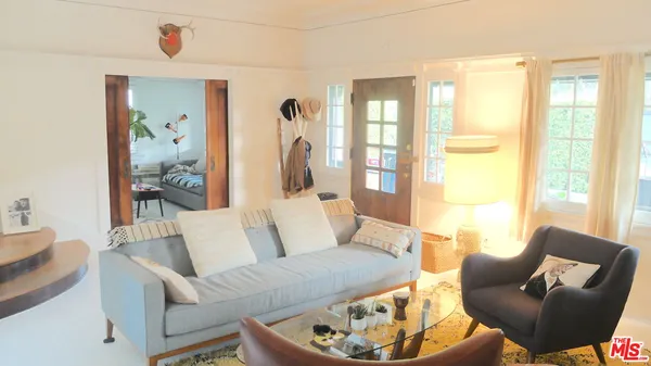 a living room with furniture wooden floor and a large window