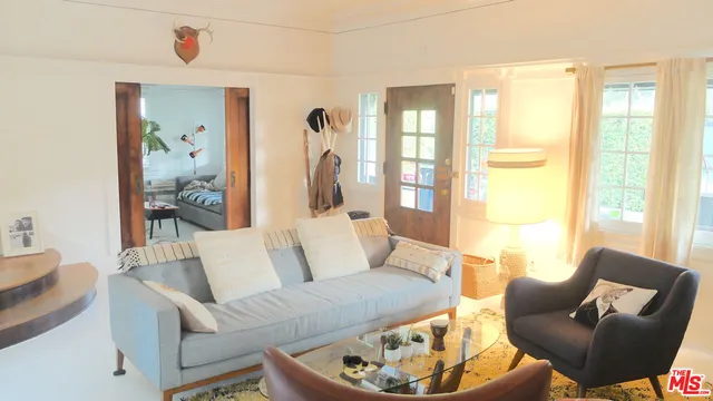 a living room with furniture wooden floor and a large window