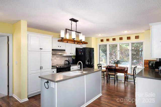 a kitchen with stainless steel appliances granite countertop a sink a stove and a refrigerator