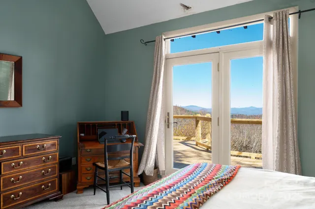 a bedroom with a bed and large windows