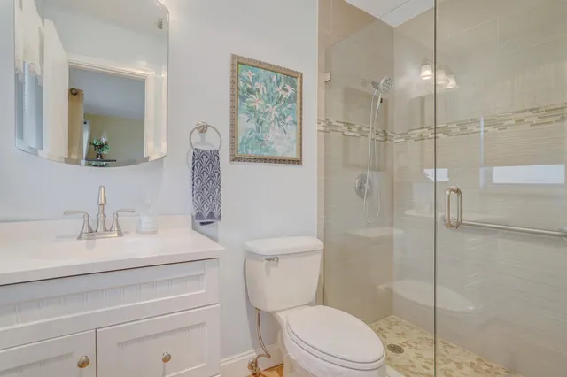 a bathroom with a sink a toilet and shower