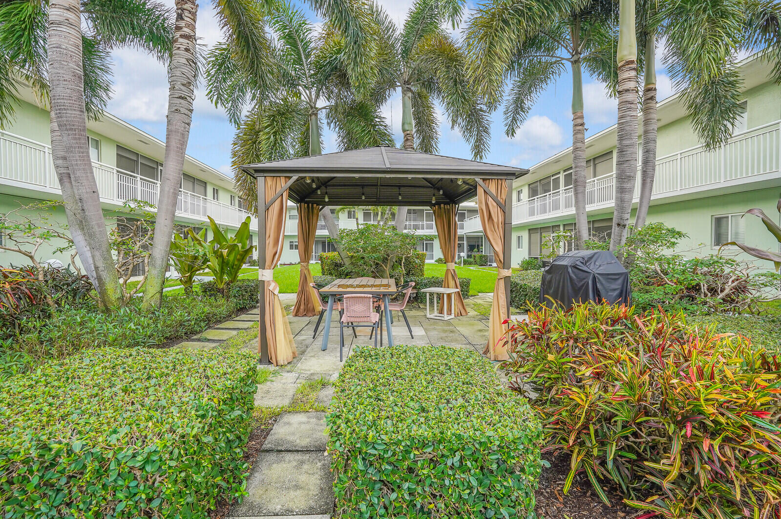 2100 Northeast 38th Street, Unit 111 Lighthouse Point, FL 33064 - Photo 19 of 25 a view of a patio with table and chairs potted plants and large tree
