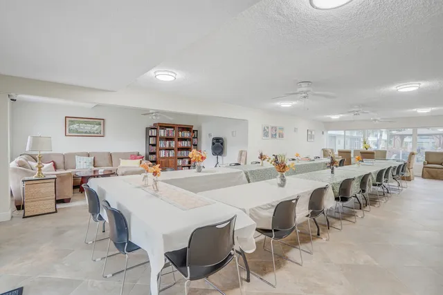 a view of a dining hall with furniture and a large window