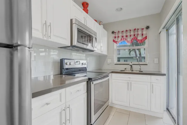 a kitchen with stainless steel appliances granite countertop a sink and cabinets
