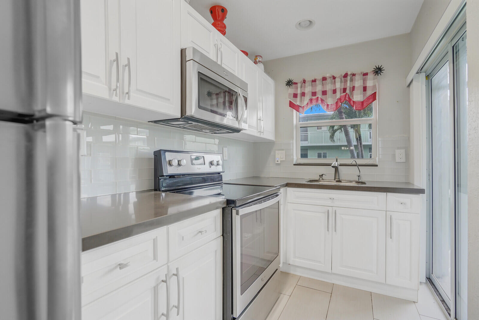 2100 Northeast 38th Street, Unit 111 Lighthouse Point, FL 33064 - Photo 8 of 25 a kitchen with stainless steel appliances granite countertop a sink and cabinets