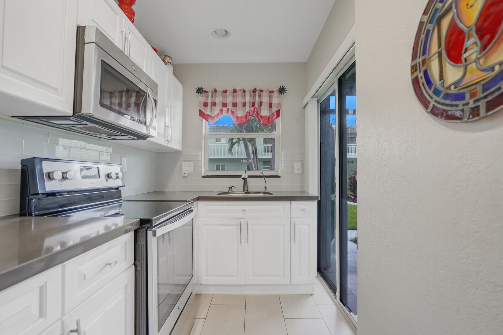 2100 Northeast 38th Street, Unit 111 Lighthouse Point, FL 33064 - Photo 9 of 25 a kitchen with stainless steel appliances granite countertop a sink and a microwave