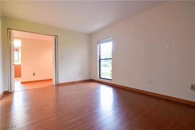 a view of an empty room with wooden floor