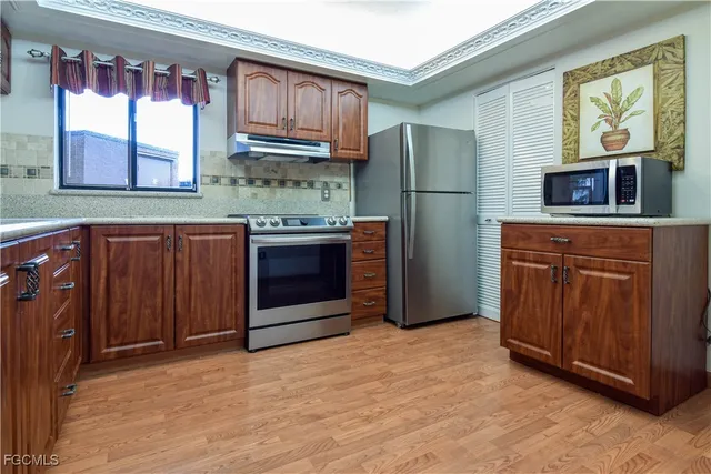 a kitchen with stainless steel appliances granite countertop a refrigerator and a sink