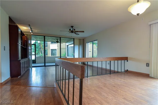 a view of a hallway with wooden floor and a chandelier
