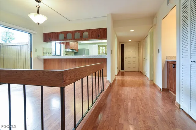a view of a big room with wooden floor and windows