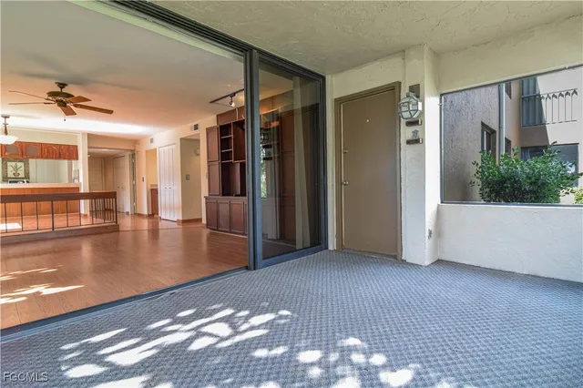 a view of a livingroom with wooden floor and a ceiling fan