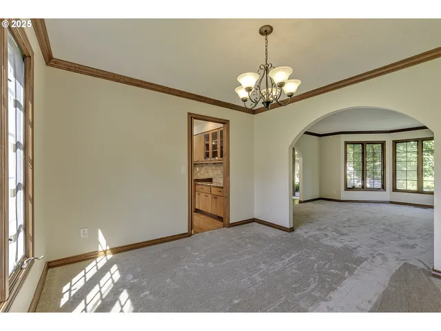 a view of a livingroom with a chandelier fan and windows