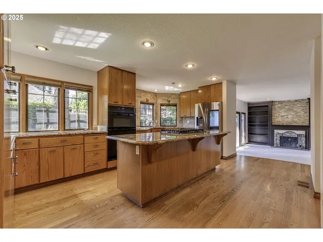 a large kitchen with a large counter top and stainless steel appliances