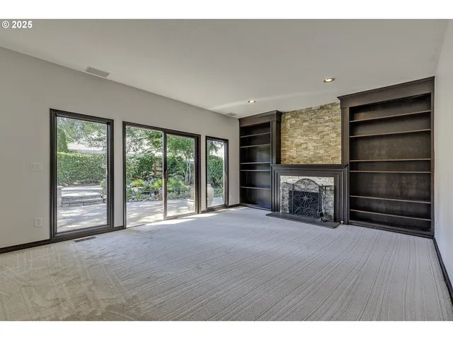 a view of an empty room with a fireplace and a window