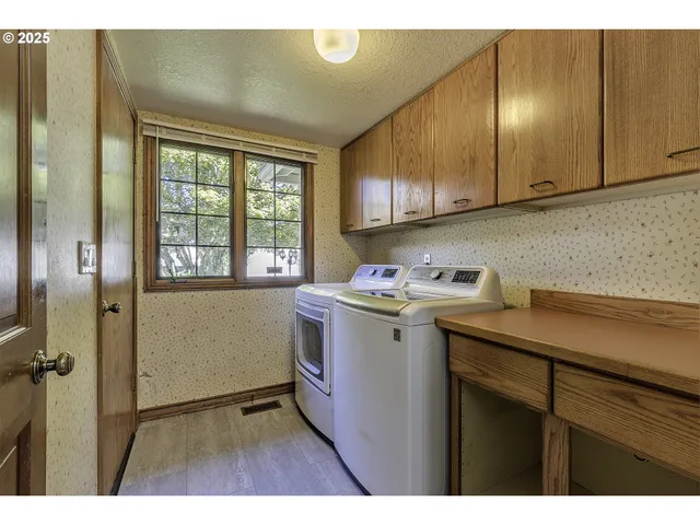 a utility room with cabinets washer and dryer