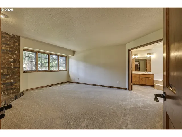 a view of an empty room and a kitchen