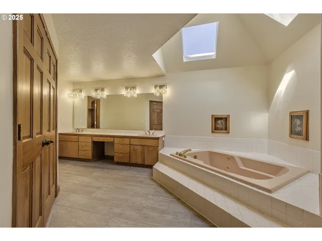 a bathroom with a tub a sink and a mirror