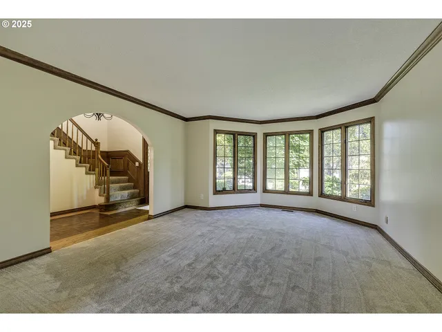 a view of an empty room with a fireplace and a window