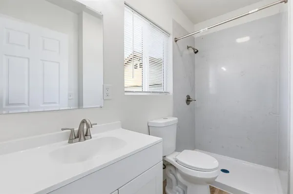 a bathroom with a sink a toilet and shower