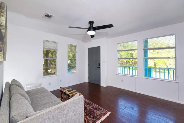 a living room with couches and a window with wooden floor