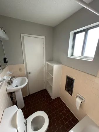 a bathroom with a toilet a sink and a mirror